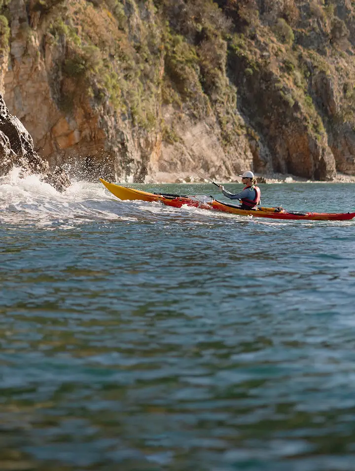 sea kayaker paddling along the rocky Adriatic coastline in Montenegro