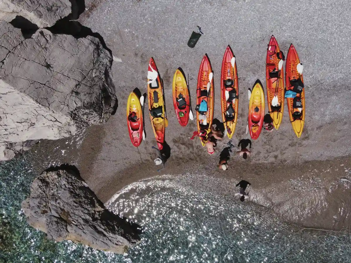 Kayaks arranged on a small pebble cove seen from above