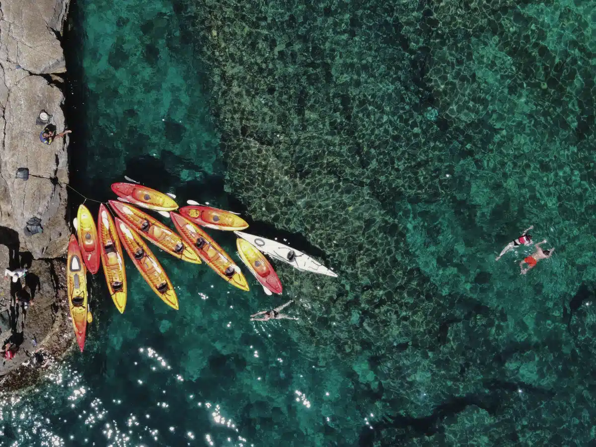 Aerial view of kayaks and swimmers over clear turquoise water