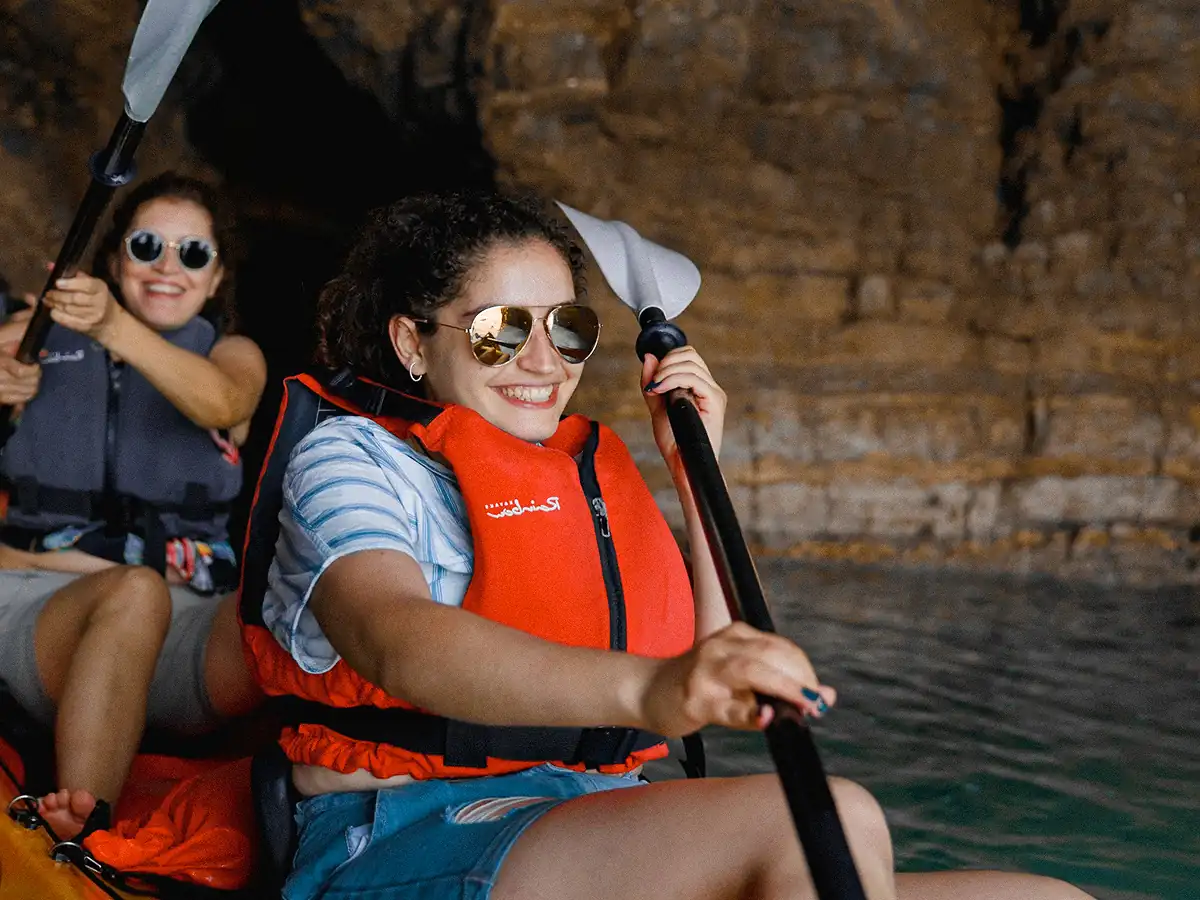 Group kayaking inside a dark of Pigeon Cave