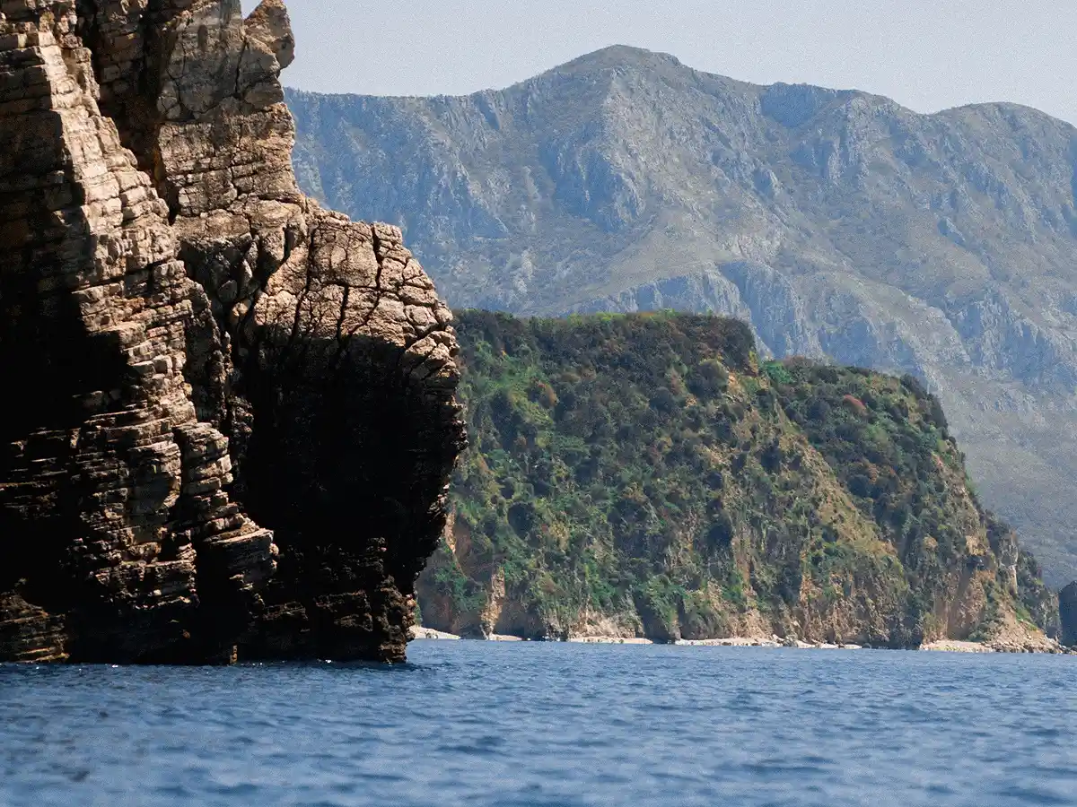 Coastal cliffs with mountains in the background