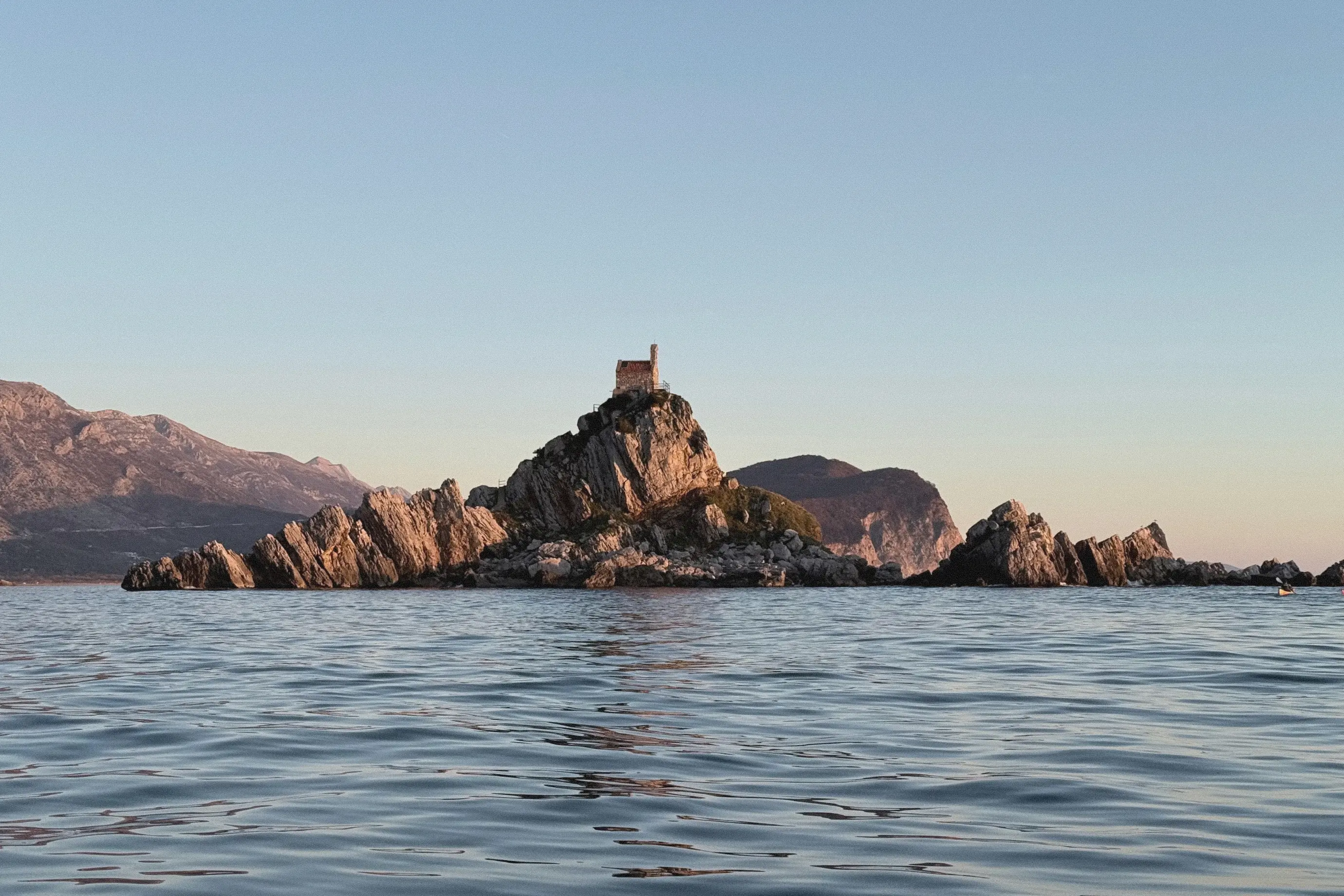 Petrovac island above calm sea at sunset