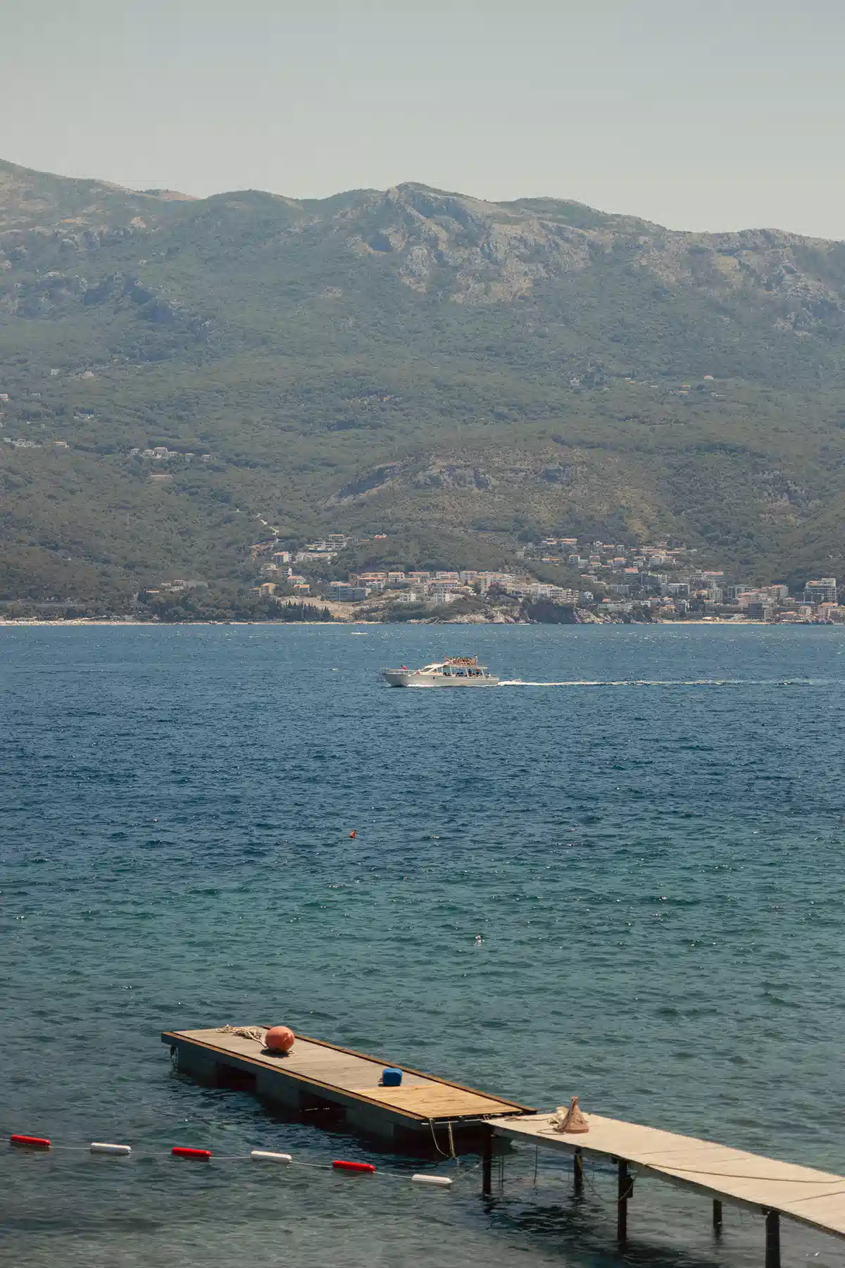 Calm bay with small island and wooden pier below the slopes of Sveti Nikola Island