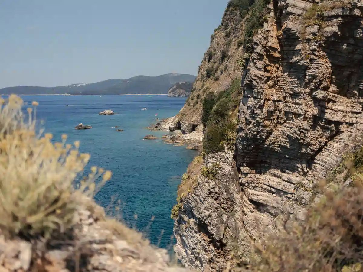Layered limestone cliffs dropping to turquoise water along the Sveti Nikola coastline