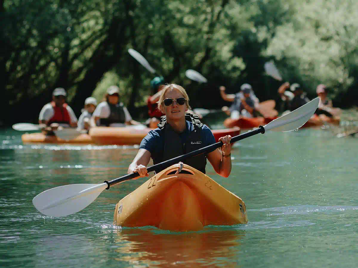Vranjina Island loop tour: woman paddling a yellow sit-on-top kayak leading a group on Skadar Lake near Vranjina Island